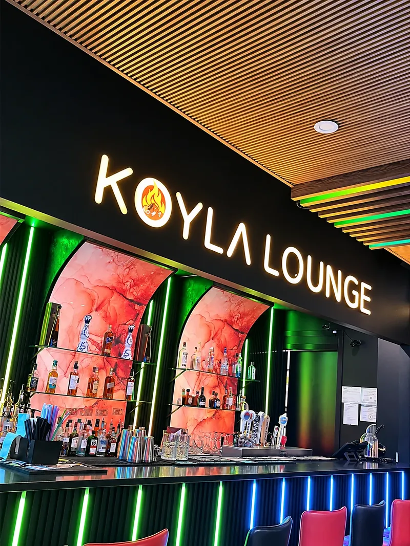 The backlit KOYLA LOUNGE sign over the bar